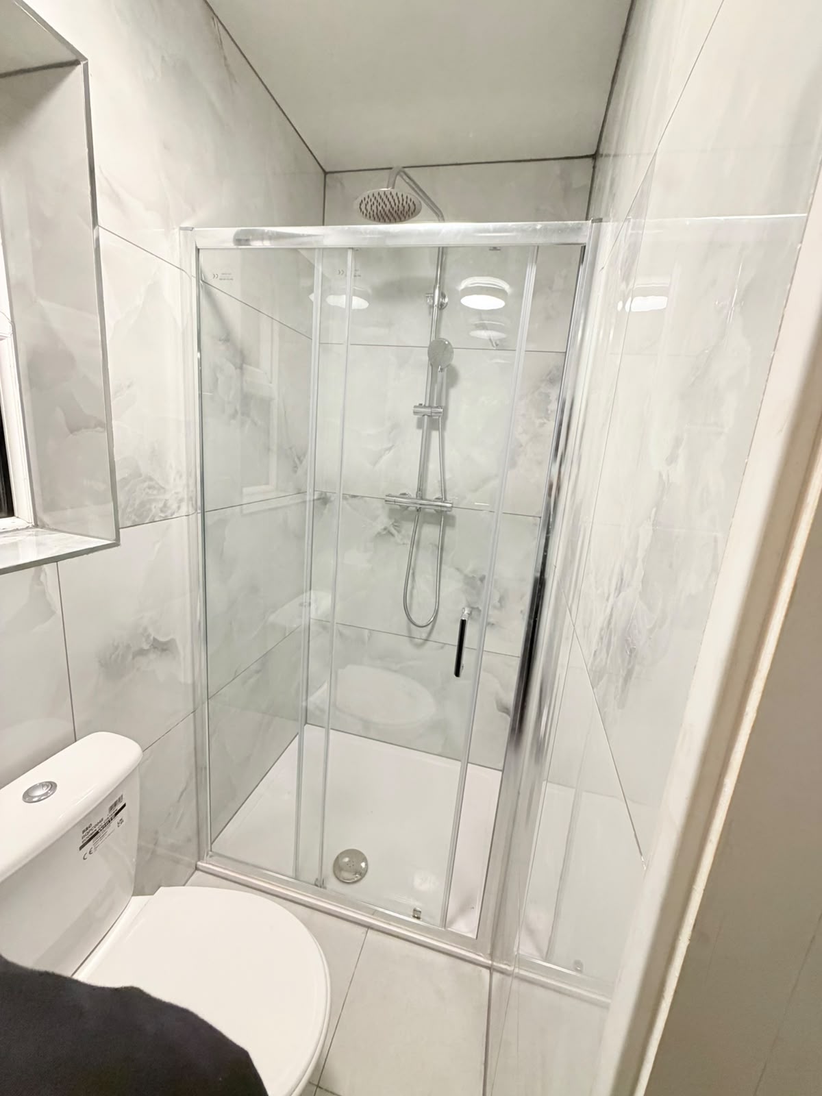 Walk-in shower with rainfall head and marble-effect tiling